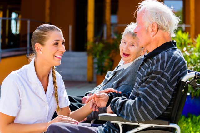 Auxiliar conversando con una pareja de ancianos