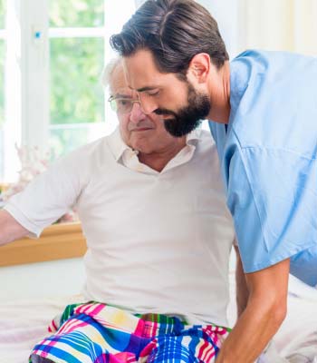 Fisioterapeuta cogiendo en brazos a un señor